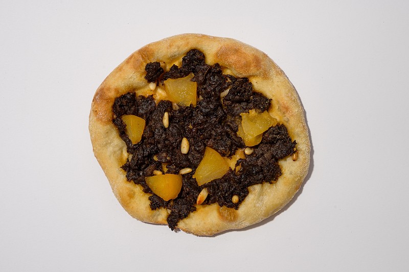 Coca de botifarra, poma i pinyons